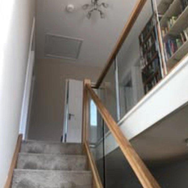 grey carpeted stairs with a wooden haindrail<br />
